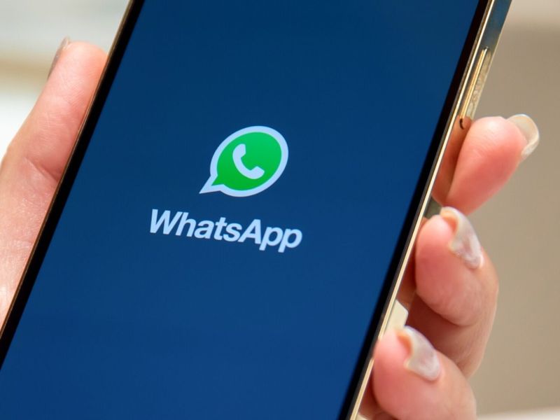 Person hält Handy mit WhatsApp in der Hand.