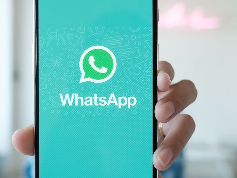 Person hält Handy mit WhatsApp in die Kamera.