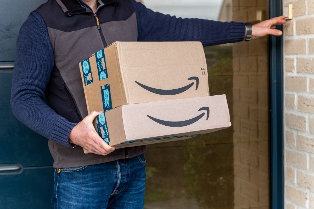 Person mit Paketen von Amazon in den Händen