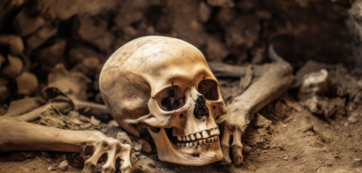 KI-generiertes Bild eines Totenschädels mit weiteren Knochen in einem Grab.