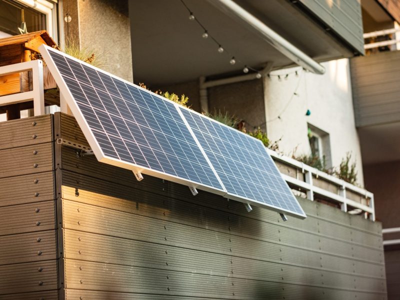 Zwei Solarpanele sind an einem Balkon montiert.