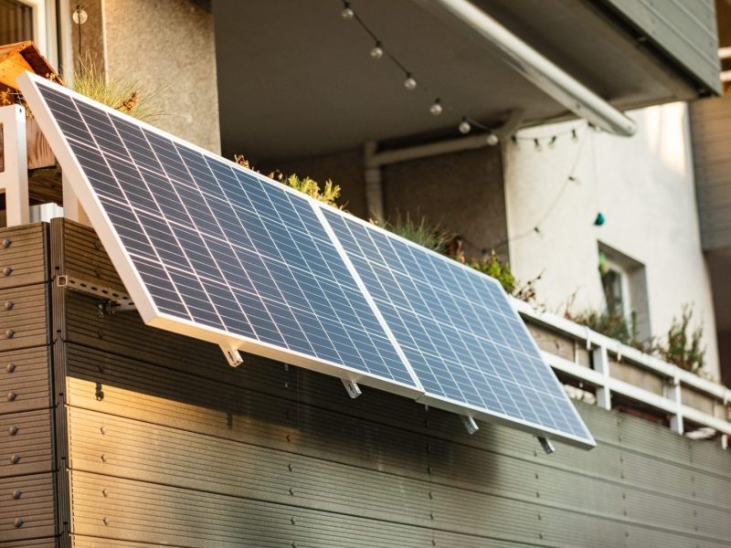 Zwei Solarpanele sind an einem Balkon montiert.