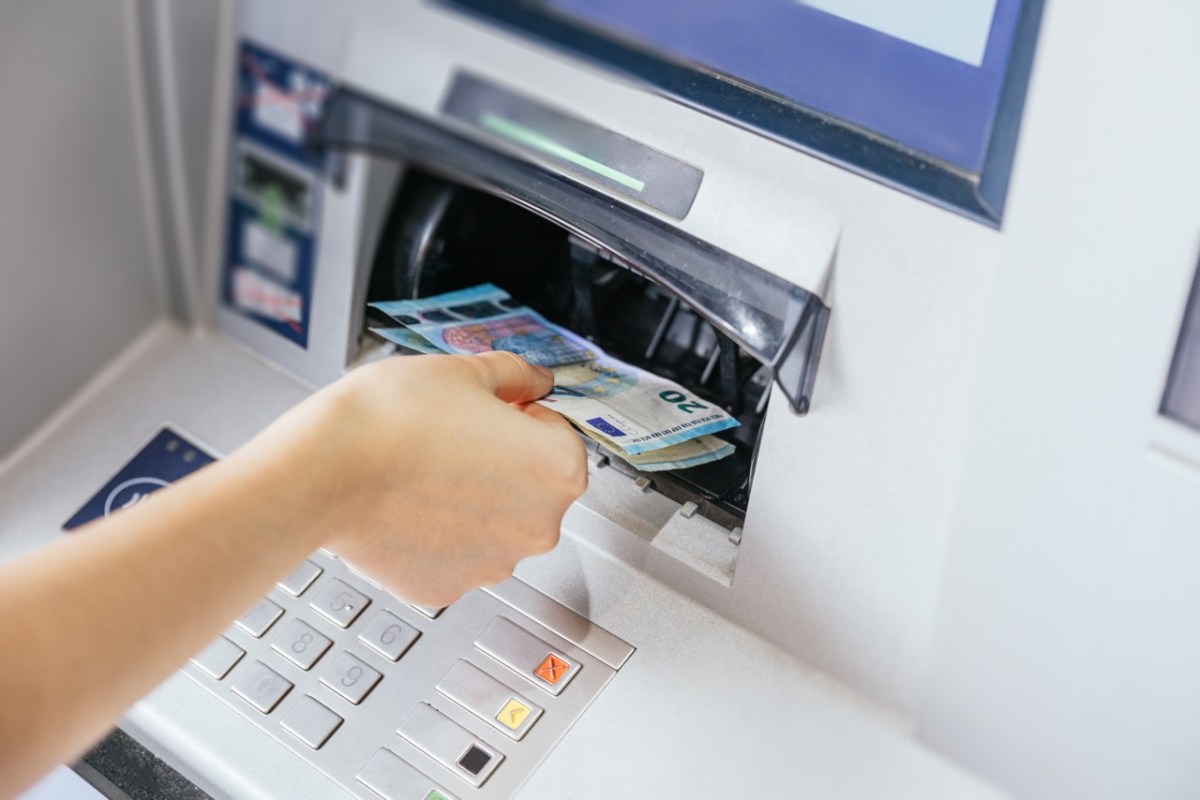 Eine Frau entnimmt Bargeld am Geldautomaten