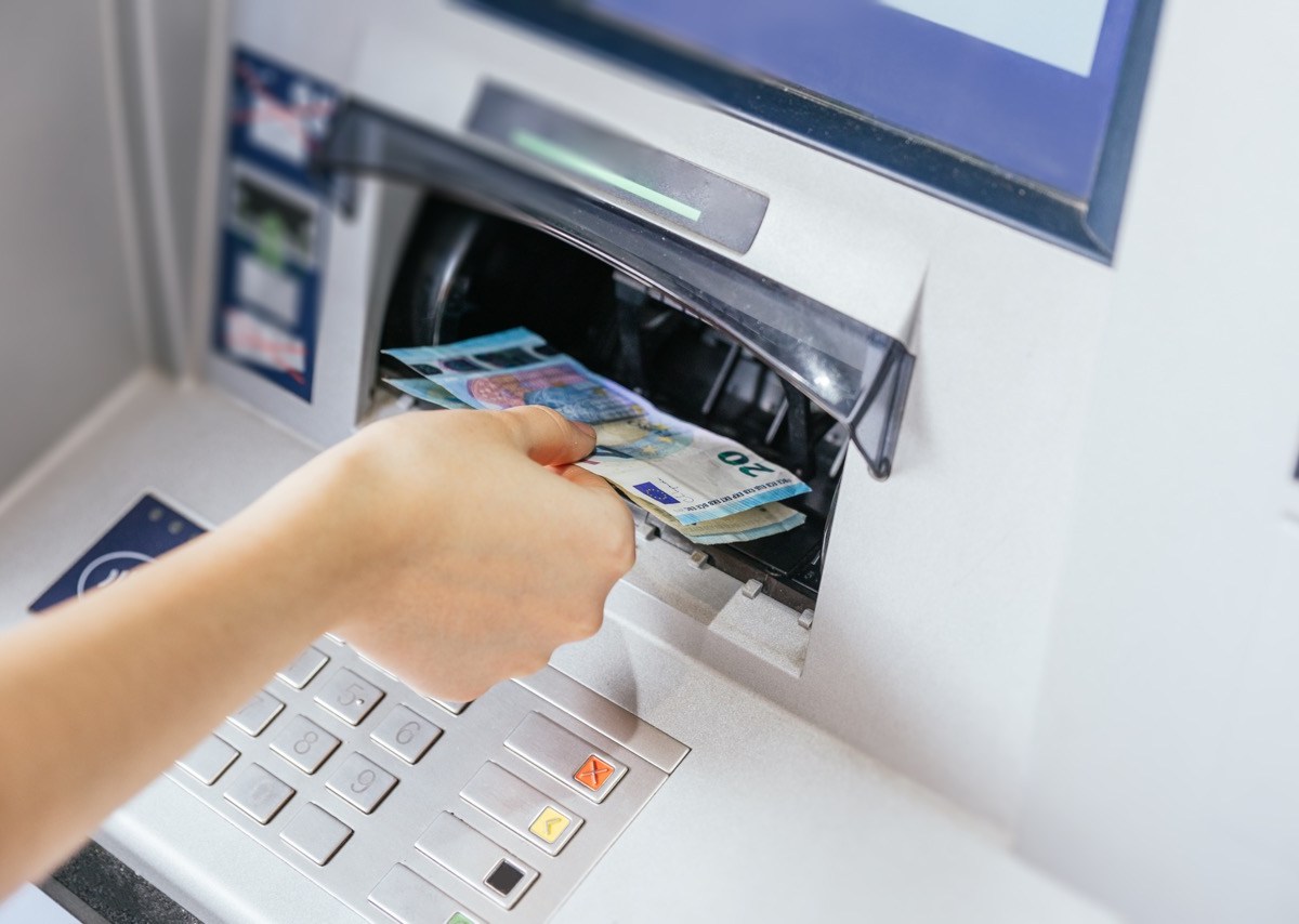 Eine Frau entnimmt Bargeld am Geldautomaten