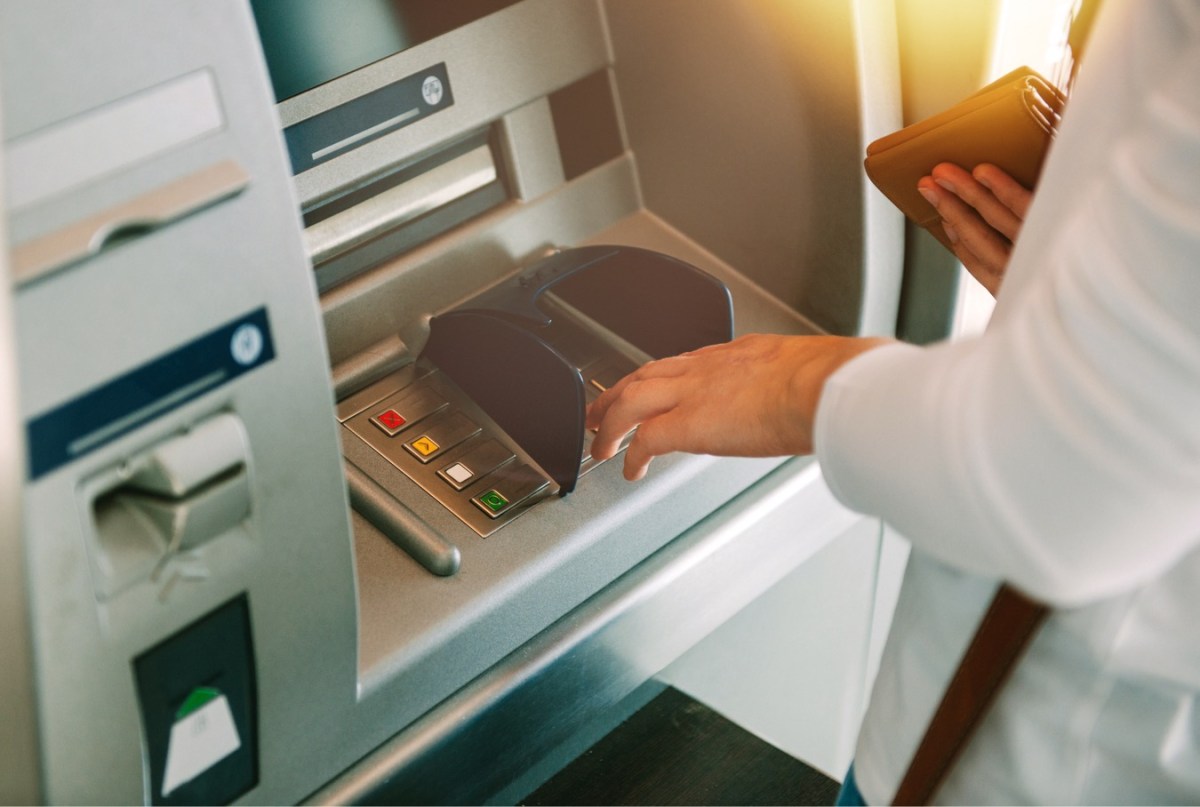 Frau hebt Geld am Geldautomaten ab