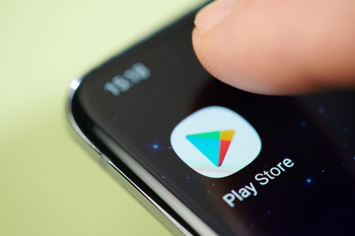 Finger tippt auf Google Play Store-Icon auf Smartphone.