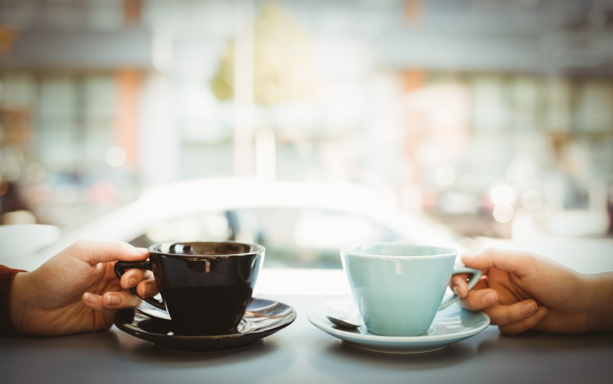 Zwei Menschen mit Tassen voll Kaffee