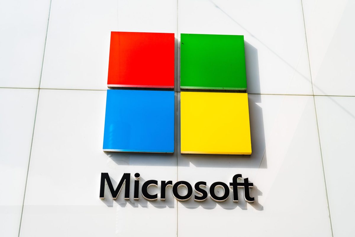 Das Logo von Microsoft hängt an einer weißen Hauswand.
