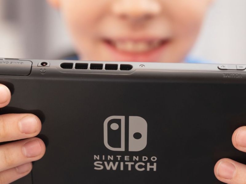 Kind hält eine Nintendo Switch in Händen.