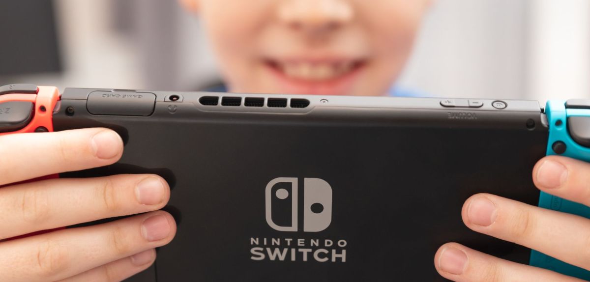 Kind hält eine Nintendo Switch in Händen.