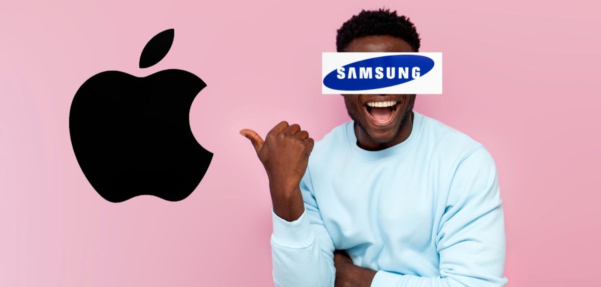 Mann, der Samsung darstellen soll, zeigt lachend auf Apple Logo
