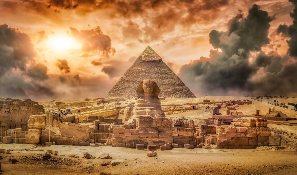 Die Sphinx vor einer Pyramide und mit Staubwolken im Hintergrund