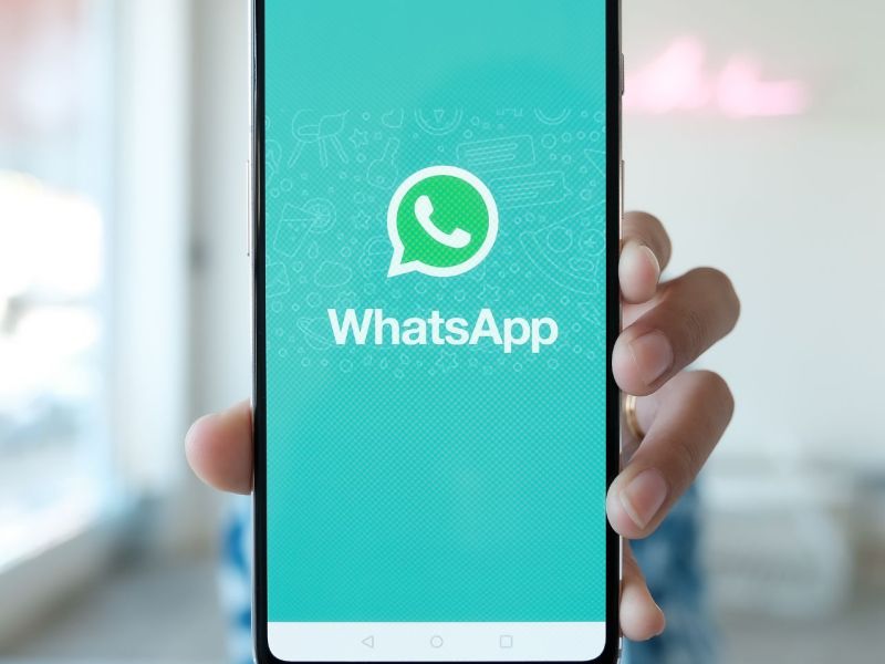 Person hält Handy mit WhatsApp in die Kamera.