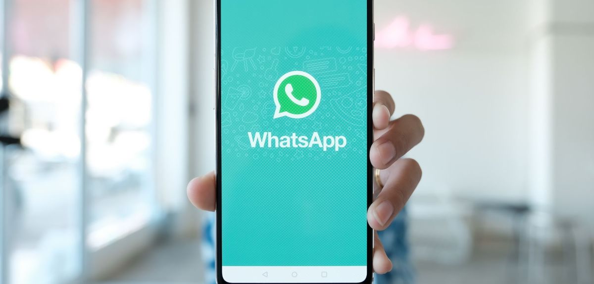 Person hält Handy mit WhatsApp in die Kamera.