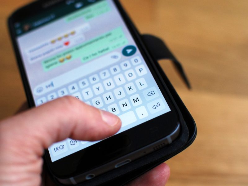 Eine Person tippt im WhatsApp Chat auf ihrem Smartphone.