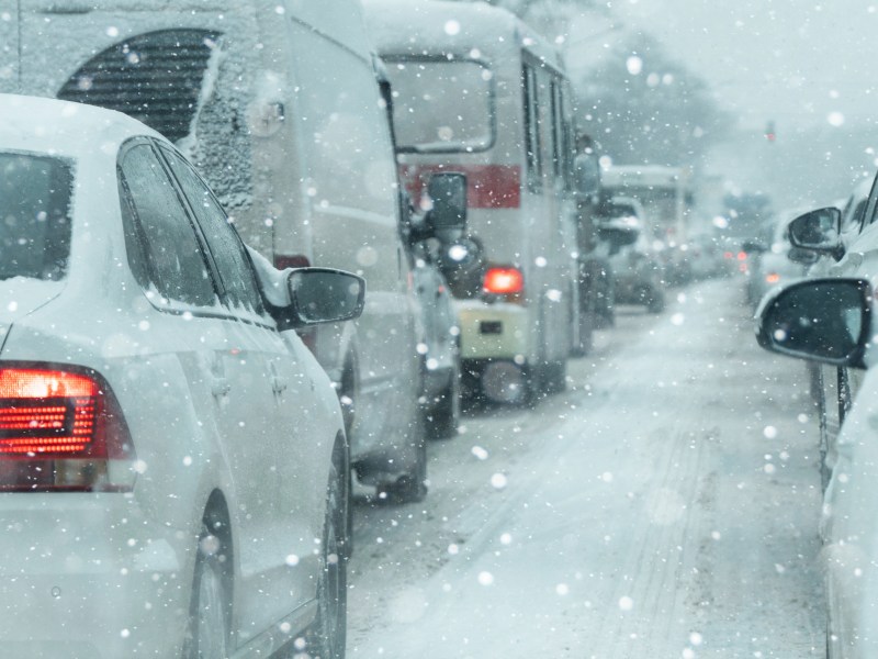 Autos stehen bei Schnee im Stau