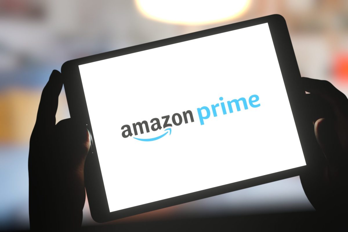 Hände halten ein Tablet, das das Logo von Amazon Prime anzeigt.
