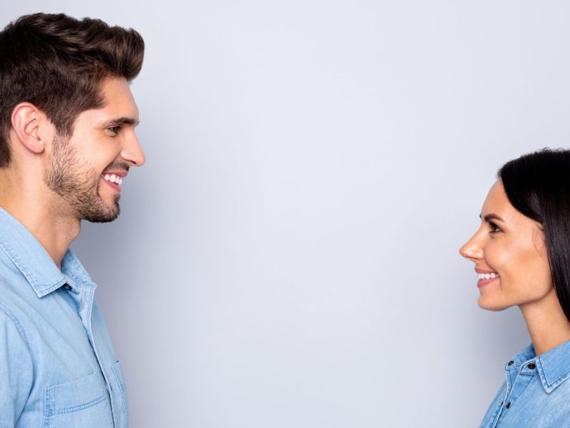 Ein Mann und eine Frau stehen sich gegenüber und schauen sich lächelnd an.