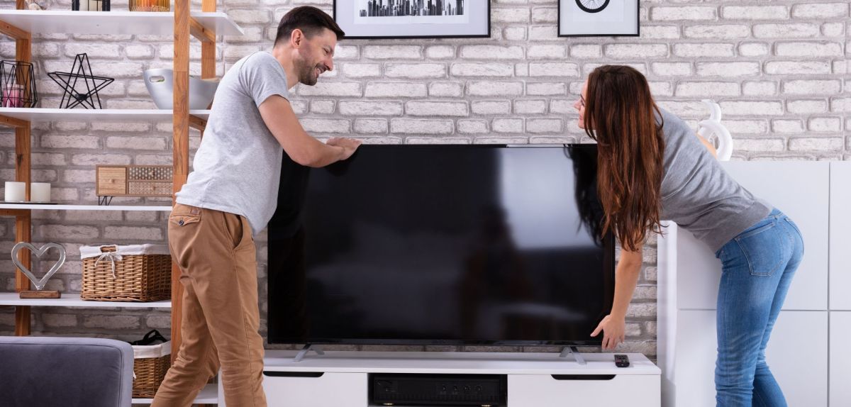 Junges paar findet Fernseher gebraucht kaufen sinnvoll