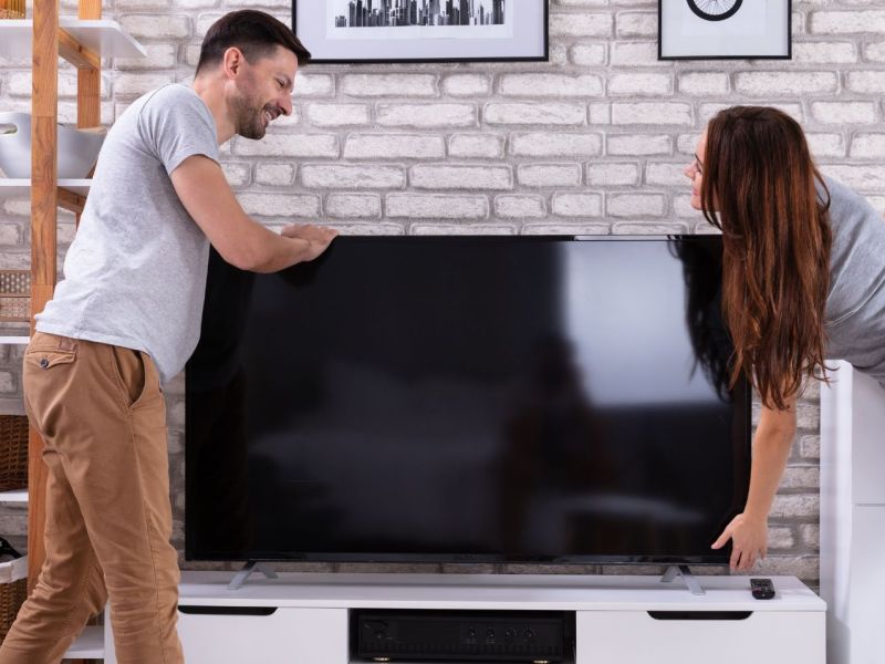 Junges paar findet Fernseher gebraucht kaufen sinnvoll