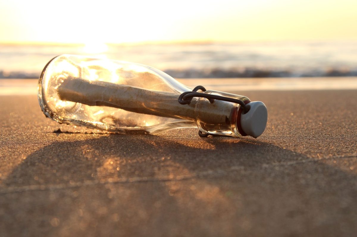 Flaschenpost bei Sonnenuntergang am Strand.