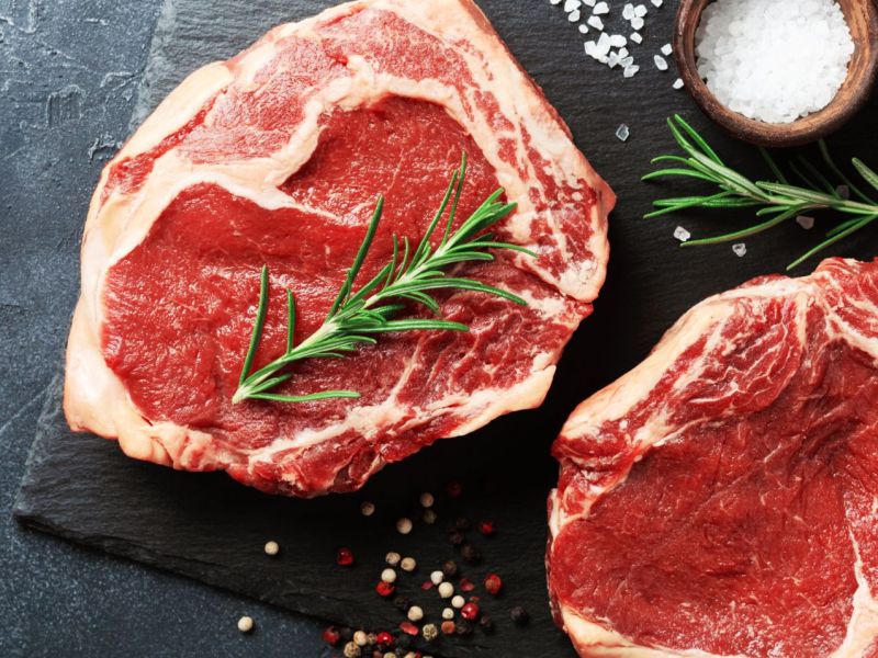 Zwei rohe Steaks auf einem Schneidebrett.