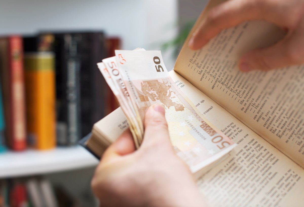 Mann versteckt Bargeld in einem Buch