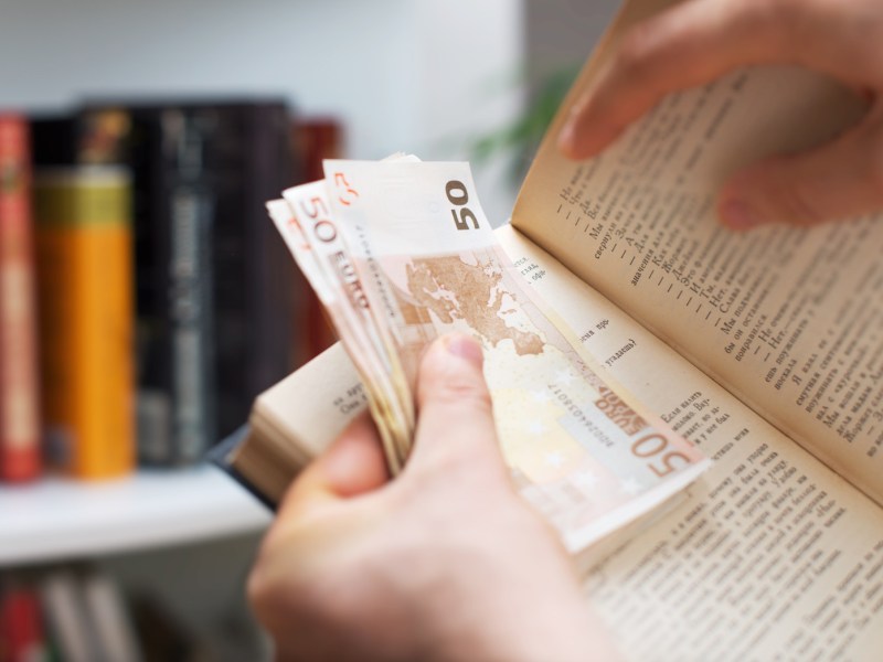 Mann versteckt Bargeld in einem Buch