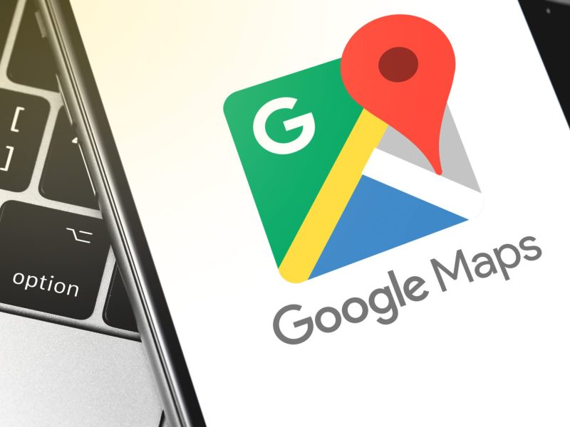 Nahansicht des Google Maps-Ladebildschirms auf einem Smartphone, das auf einer Tastatur liegt.