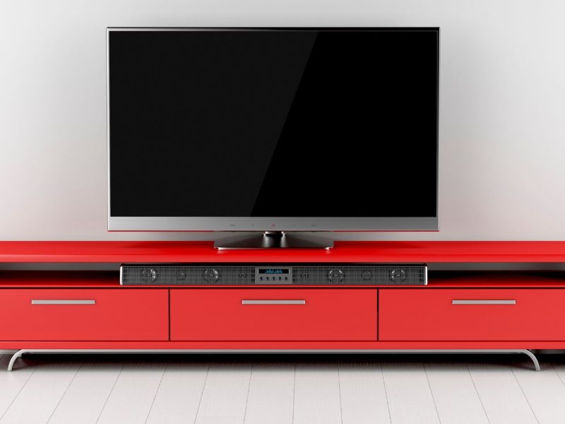 Fernseher mit Soundbar und Lautsprecher.