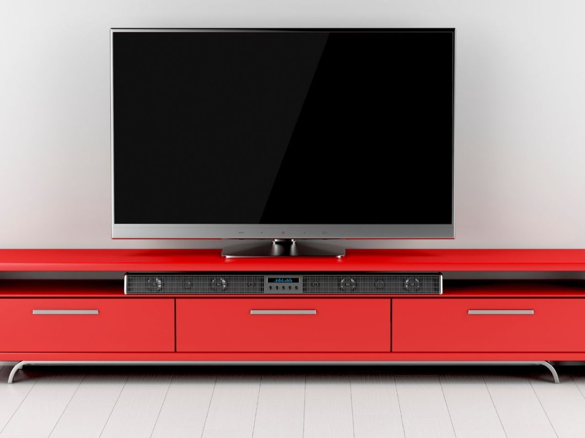 Fernseher mit Soundbar und Lautsprecher.