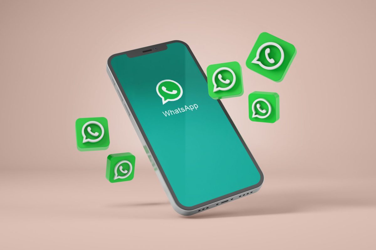 Mehrere WhatsApp Logos fliegen von einem Smartphone weg.