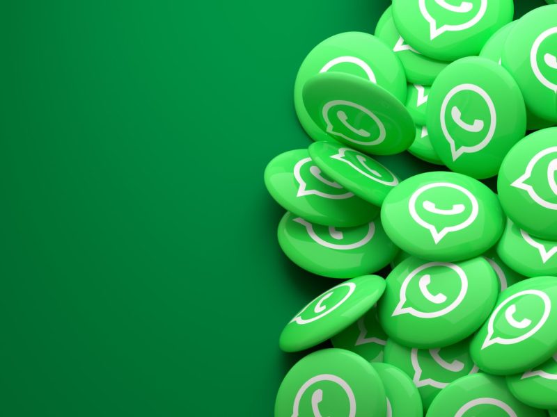 Mehrere WhatsApp Logos auf grünem Hintergrund.