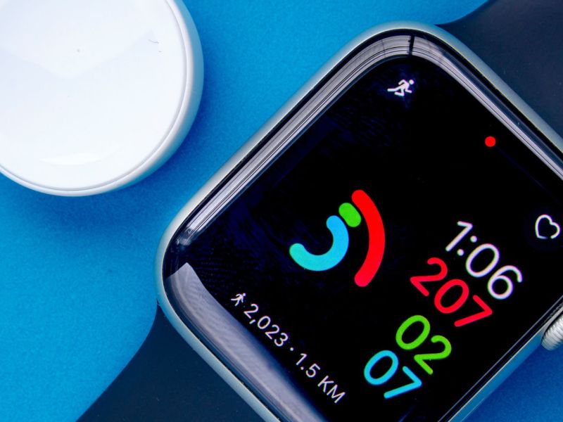 Eine Apple Watch Series 6 mit einem Ladegerät auf blauem Untergrund.