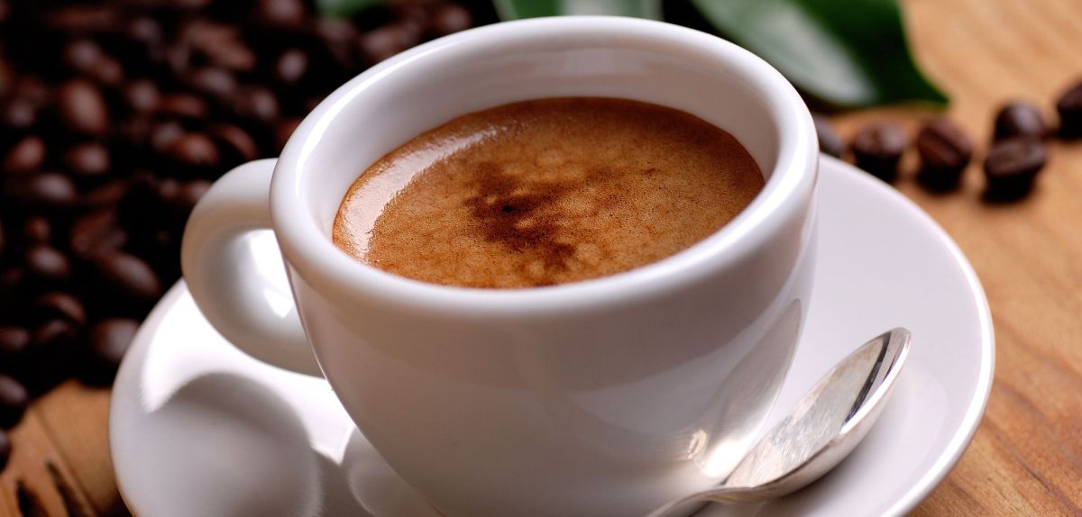 Eine Tasse Espresso nebst Kaffeebohnen