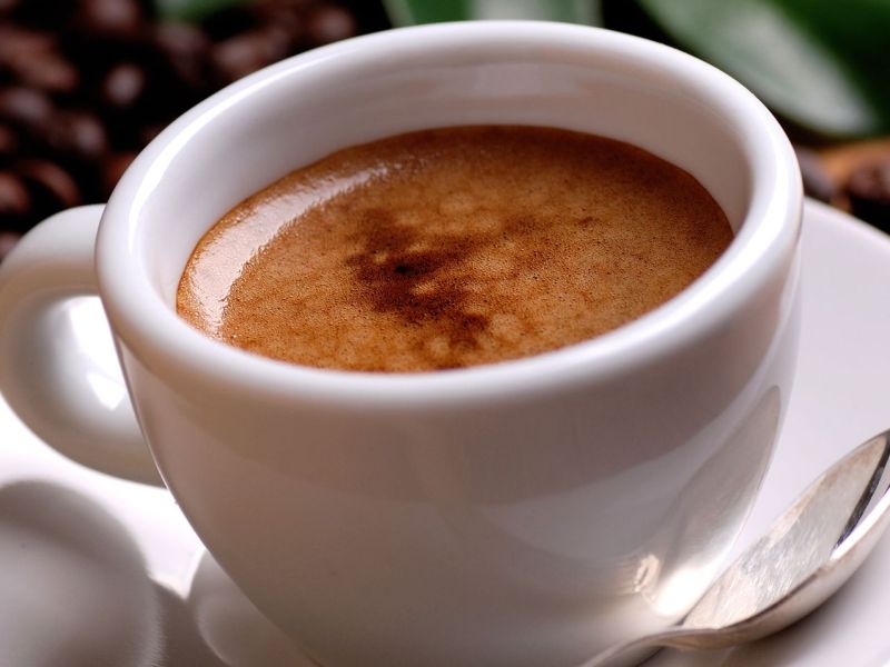 Eine Tasse Espresso nebst Kaffeebohnen