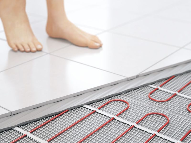 Grafische Darstellung einer Person, die auf einem Boden mit Fußbodenheizung steht.