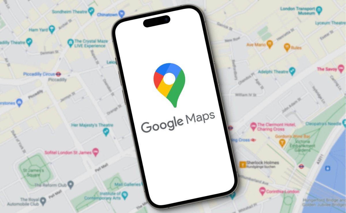 Das Logo von Google Maps erscheint auf einem Smartphone während im Hintergrund eine große Karte zu sehen ist.