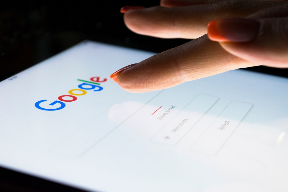Person tippt mit dem Finger auf das Google-Suchfeld