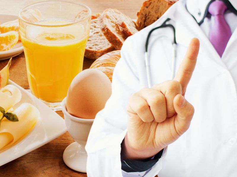 Arzt zeigt mit dem Finger wegen Frühstückslebensmitteln