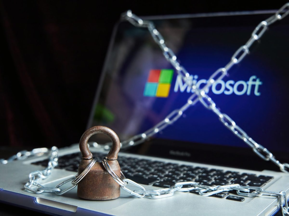 Laptop mit Microsoft in Ketten symbolisiert unerlaubten Datenzugriff.