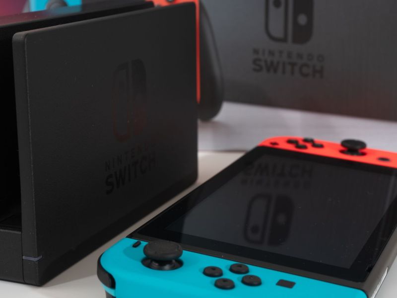 Eine Nintendo Switch liegt neben einer Dockingstation.