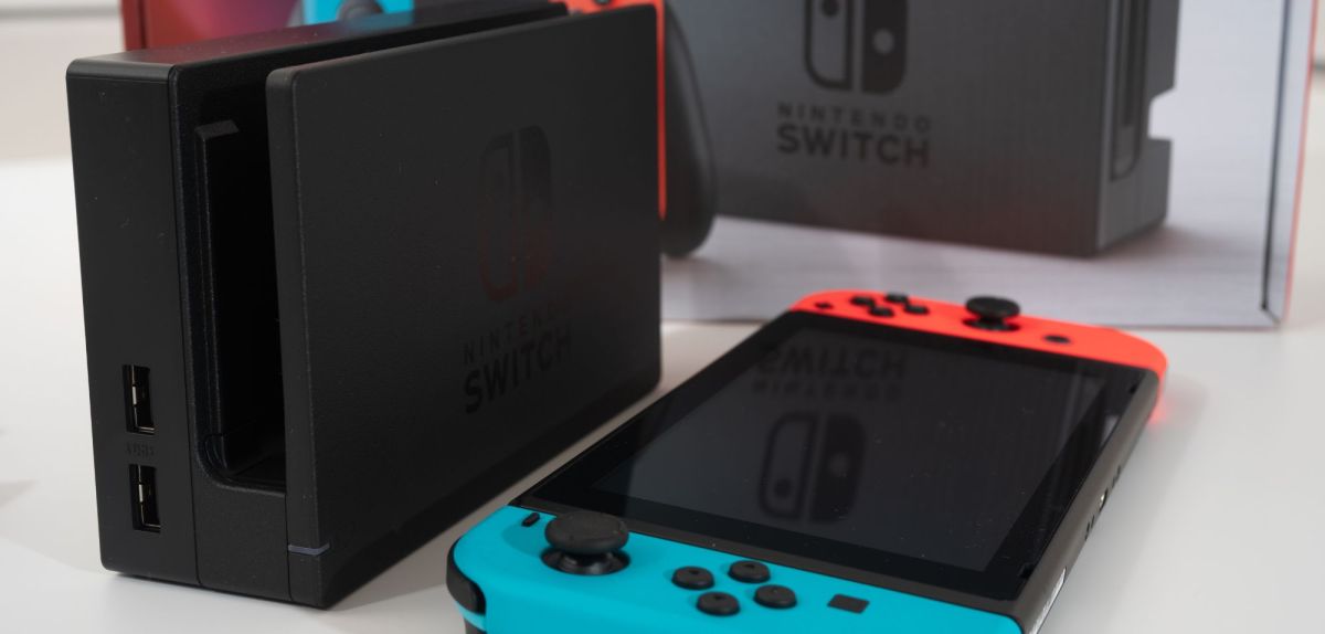 Eine Nintendo Switch liegt neben einer Dockingstation.