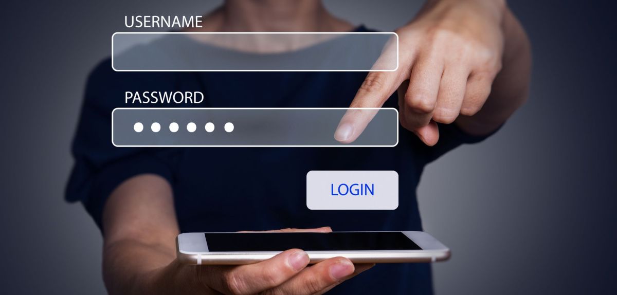 Mann zeigt mit Finger auf Handy, darüber sind Eingabemasken für Username und Passwort zu sehen.