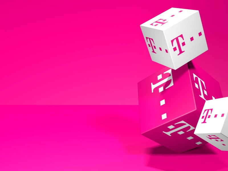 Drei Würfel mit dem Logo der Telekom vor magentafarbenen Hintergrund.