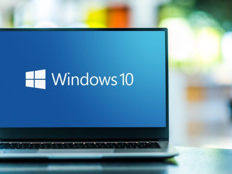 Laptop mit Windows 10-Startbildschirm vor unscharfem Hintergrund.