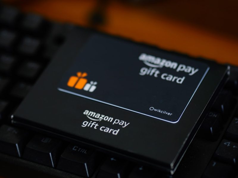 Amazon-Geschenkkarte liegt auf dunklem Hintergrund.