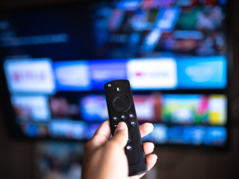 Ansicht eines Amazon Fire TV mit Fernbedienung davor.