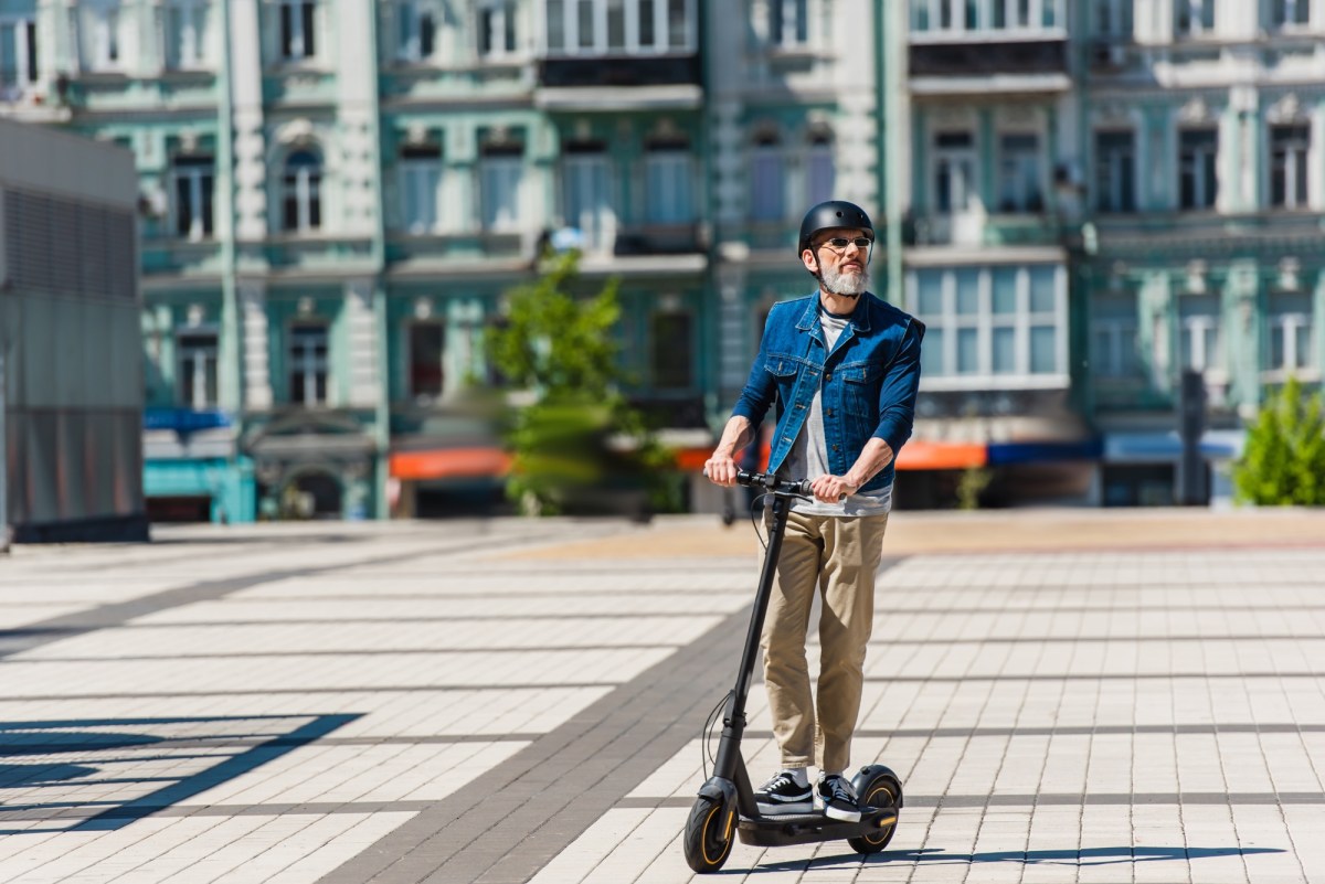 Mann auf einem E-Scooter in der Stadt.