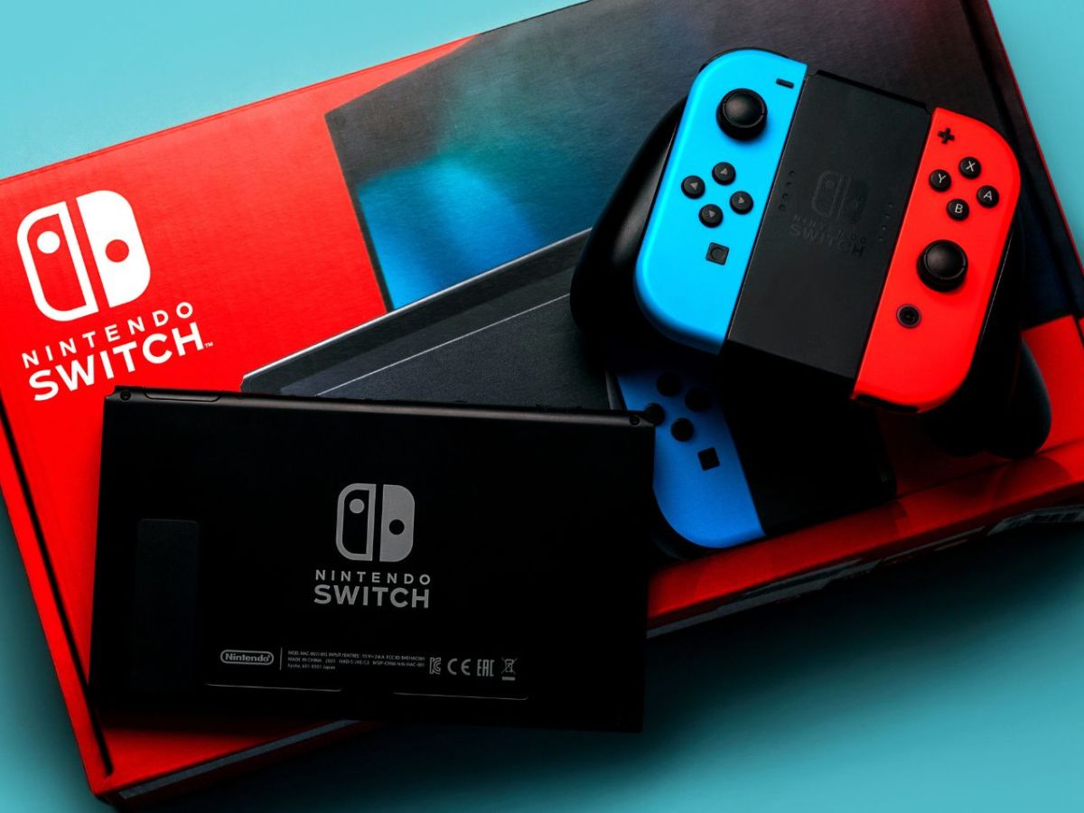 Eine Nintendo Switch mitsamt Verpackung auf blauem Untergrund.